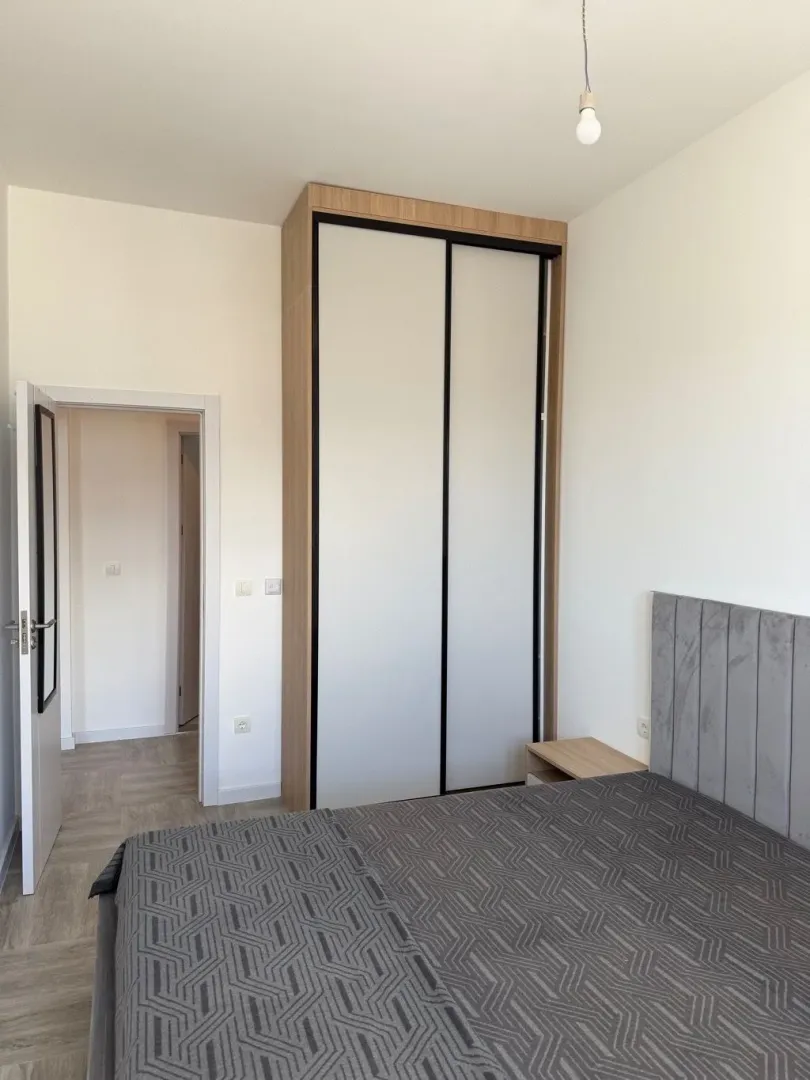 Furnished bedroom with a double bed and a built-in wardrobe.