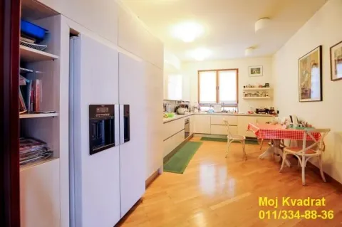 Spacious kitchen with a dining table and built-in refrigerator. - image 6