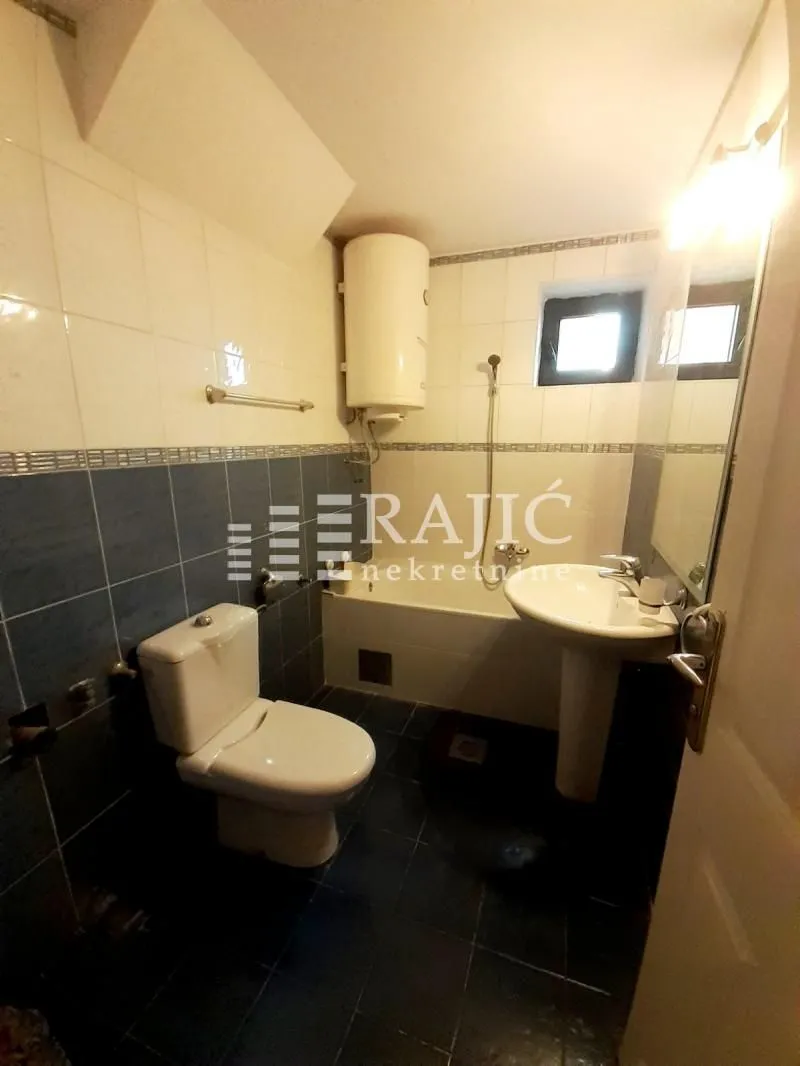 Smaller bathroom with sanitary facilities, shower, and water heater.