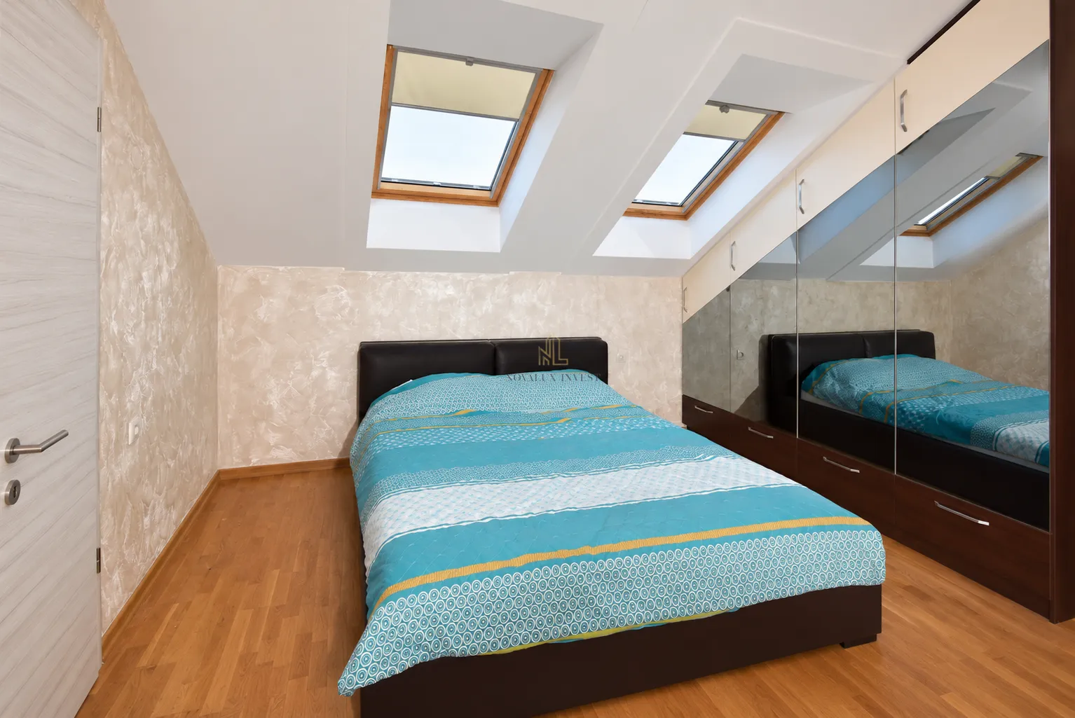 Attic bedroom with a double bed, skylights, and a fitted wardrobe.