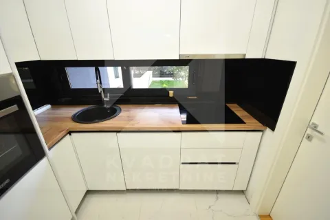 Modern white kitchen with a sink and a built-in cooktop. - image 5
