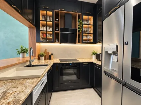 Moderna crna kuhinja sa ugrađenim aparatima i šankom. - image 6