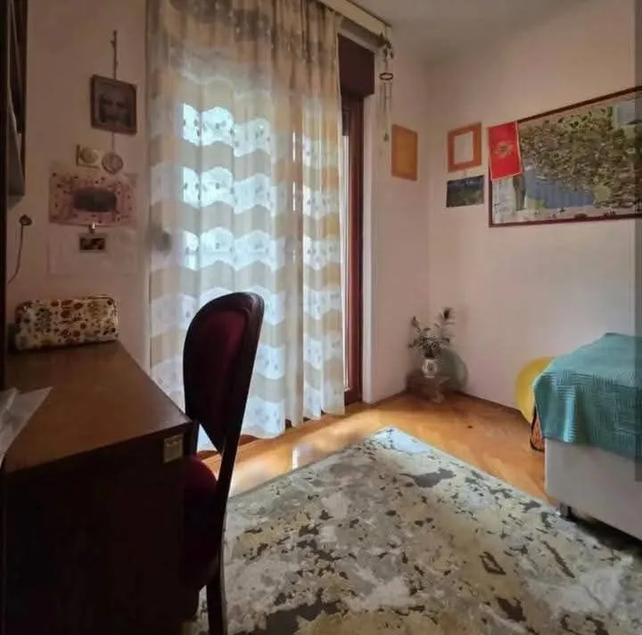 Namještena spavaća soba sa radnim stolom i krevetom.