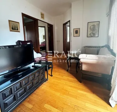 Living room with furniture, TV, and wooden flooring. - image 9
