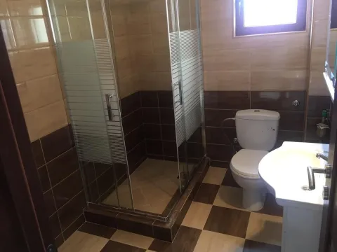 A bathroom featuring a glass shower cabin and tiled walls. - image 8