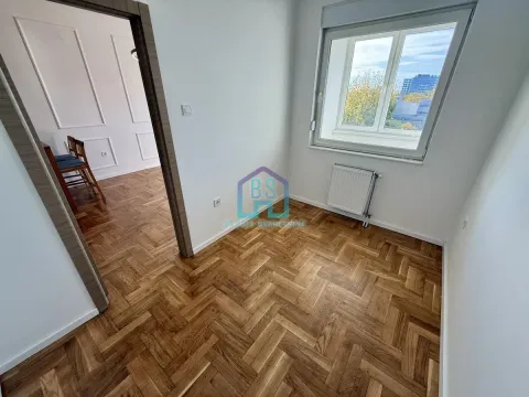 Prazna soba sa parketom i prozorom, sa pogledom na susednu prostoriju. - image 3