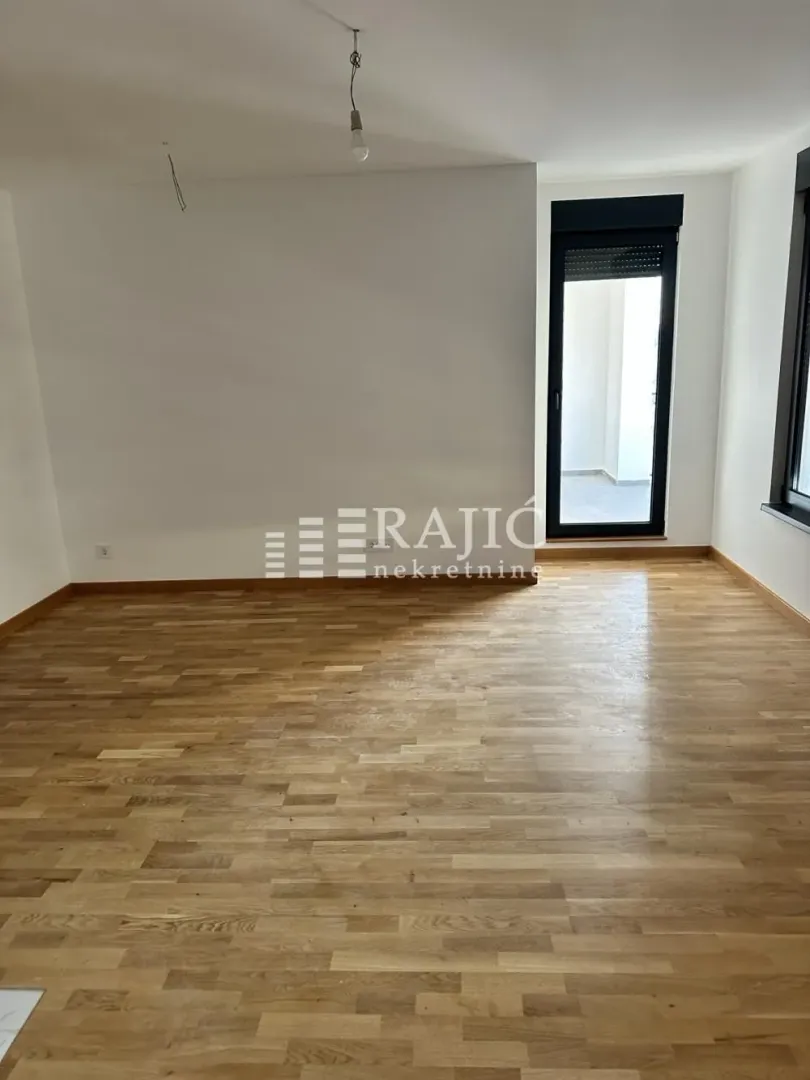 Empty room with hardwood floors and white walls.