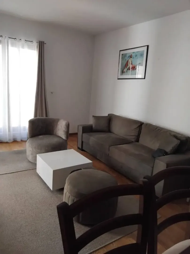 Dnevna soba sa garniturom, foteljom i stočićem.
