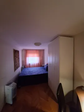 A simply furnished bedroom with a double bed and a white wardrobe. - image 10