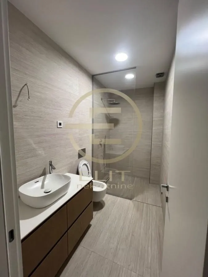 Modernly equipped bathroom with a washbasin, shower cabin and toilet.