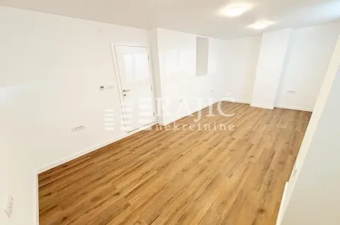 Empty room with laminate flooring and white walls. - image 2