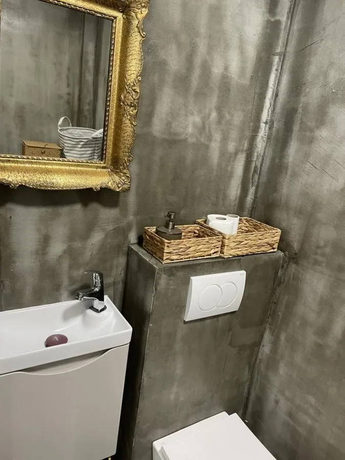 Manje kupatilo sa umivaonikom, ogledalom i WC šoljom.