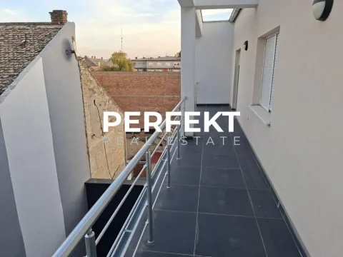 Dugačak popločani balkon sa metalnom ogradom i pogledom na okolne zgrade. - image 9