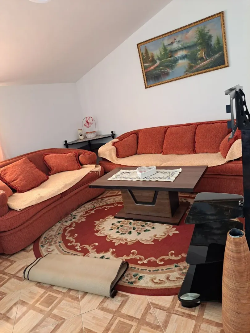 Living room with red sofas, a coffee table, and a painting on the wall.
