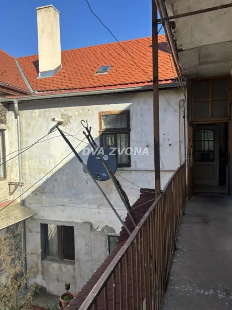 Pogled sa spoljne terase na staru fasadu i krov kuće.