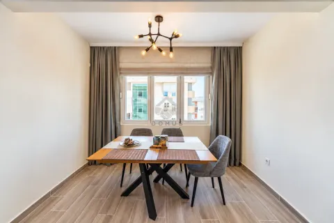 Dining area with a wooden table and four grey chairs by the window. - image 18