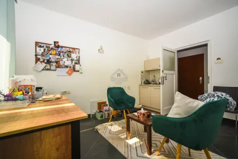 Living room with a desk and green armchairs. - image 2