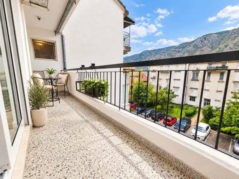 Namtješten balkon sa garniturom za sjedenje i pogledom na naselje i planine. - image 11