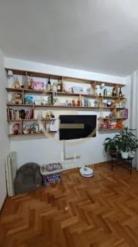 Dnevna soba sa zidnim policama, knjigama i televizorom. - image 6