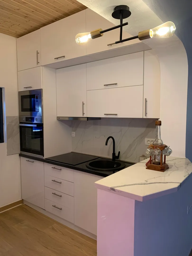 Modern kitchen with white cabinetry and built-in appliances.