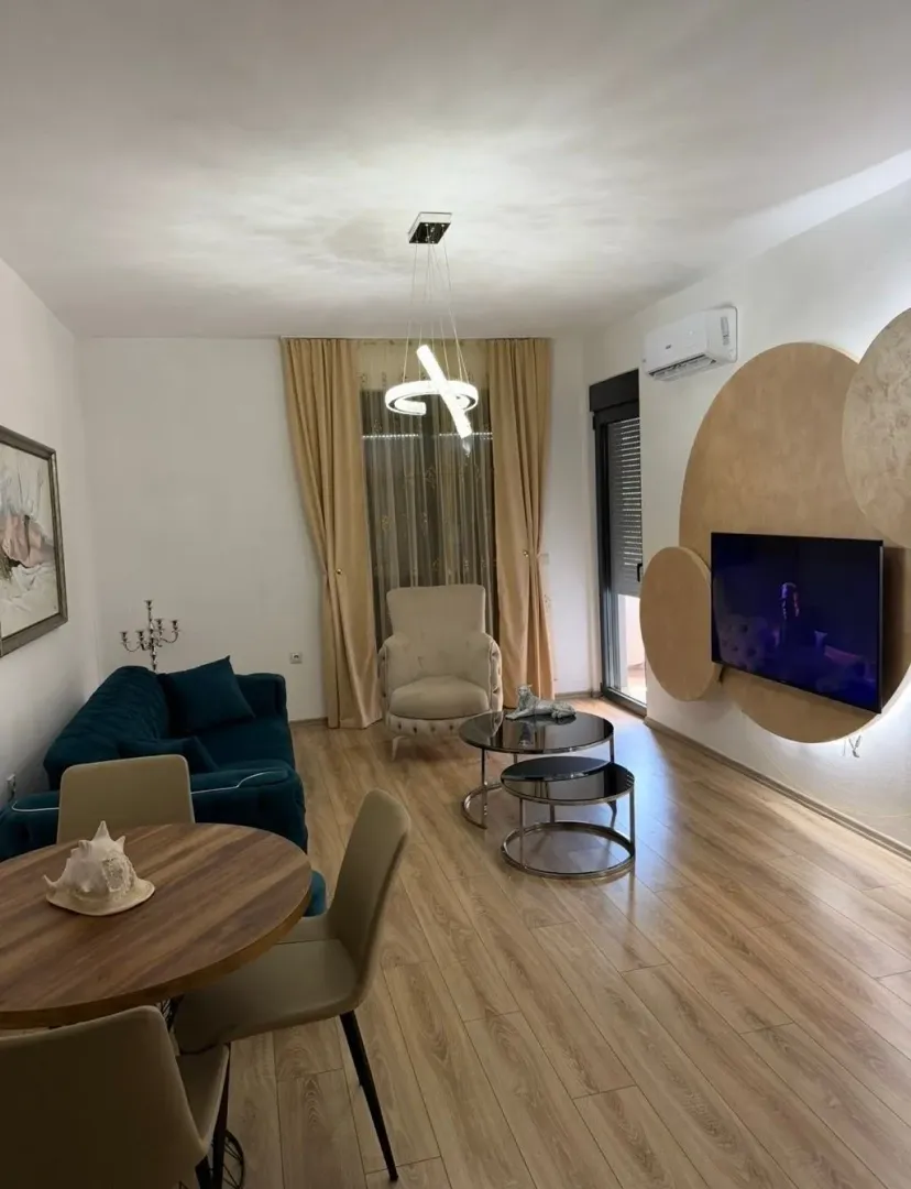 Moderan dnevni boravak sa garniturom, trpezarijskim stolom i TV-om.
