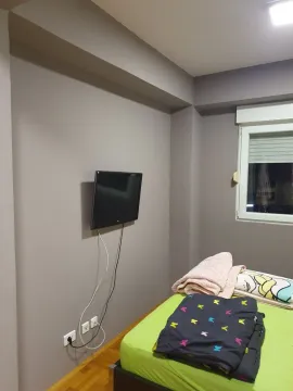 Spavaća soba sa televizorom montiranim na zidu i krevetom. - image 11