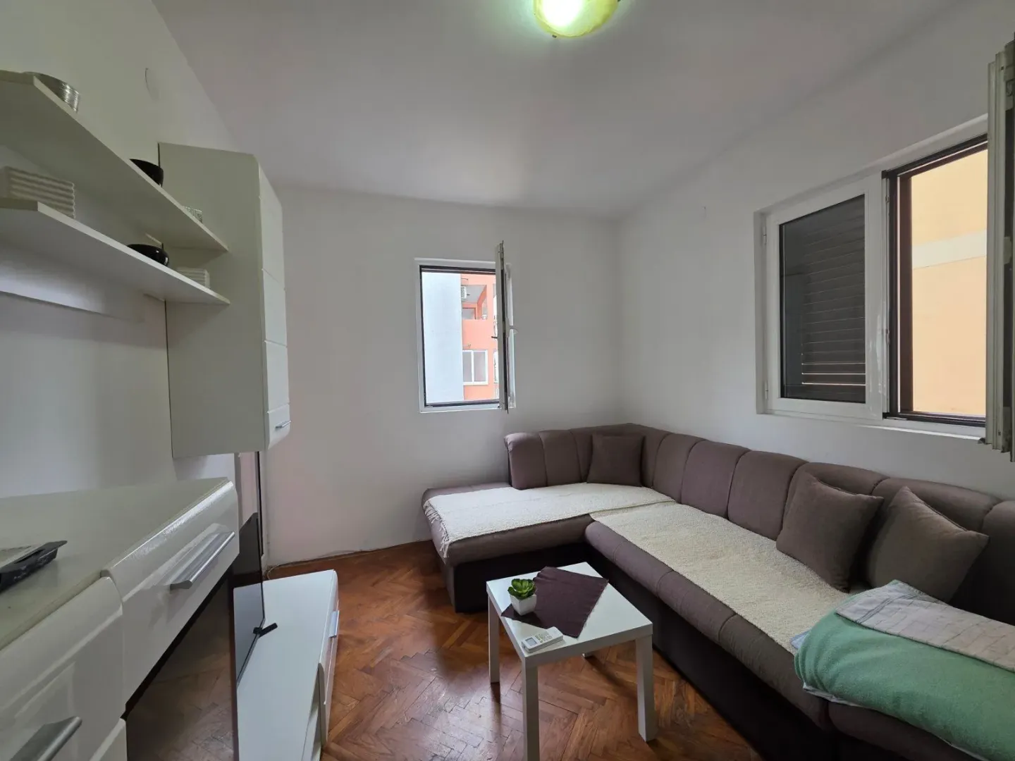 Living room with a sectional sofa, coffee table, and white furniture.