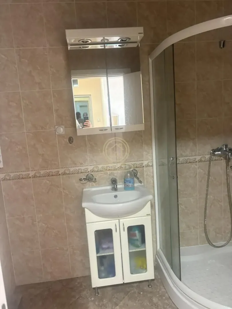 Bathroom equipped with a vanity basin, mirror, and shower cabin.