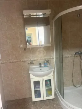 Bathroom equipped with a vanity basin, mirror, and shower cabin. - image 4
