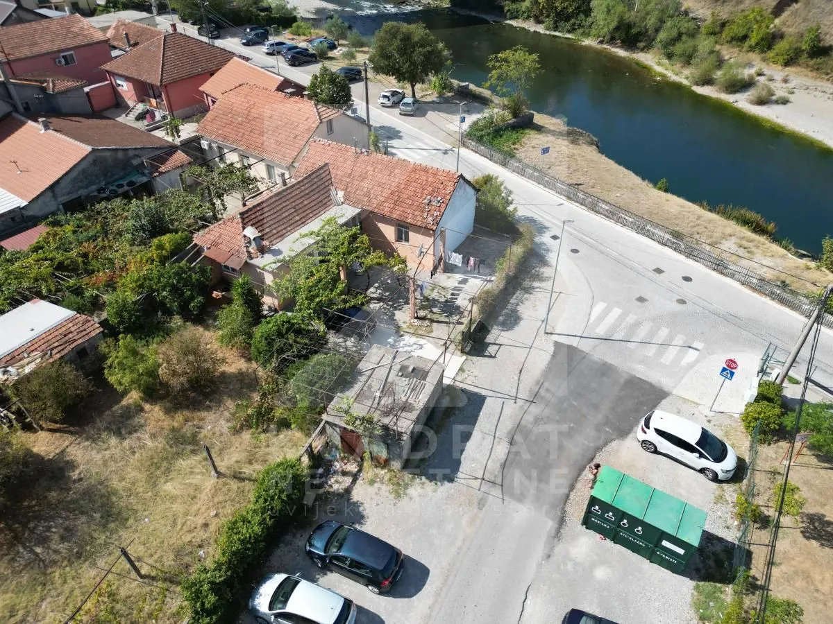 Pogled iz vazduha na kuću sa dvoriijem i okruženjem u blizini rijeke.