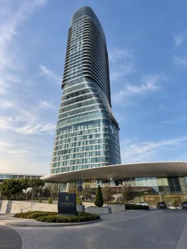 Exterior view of a modern multi-story building with a landscaped driveway. - image 2