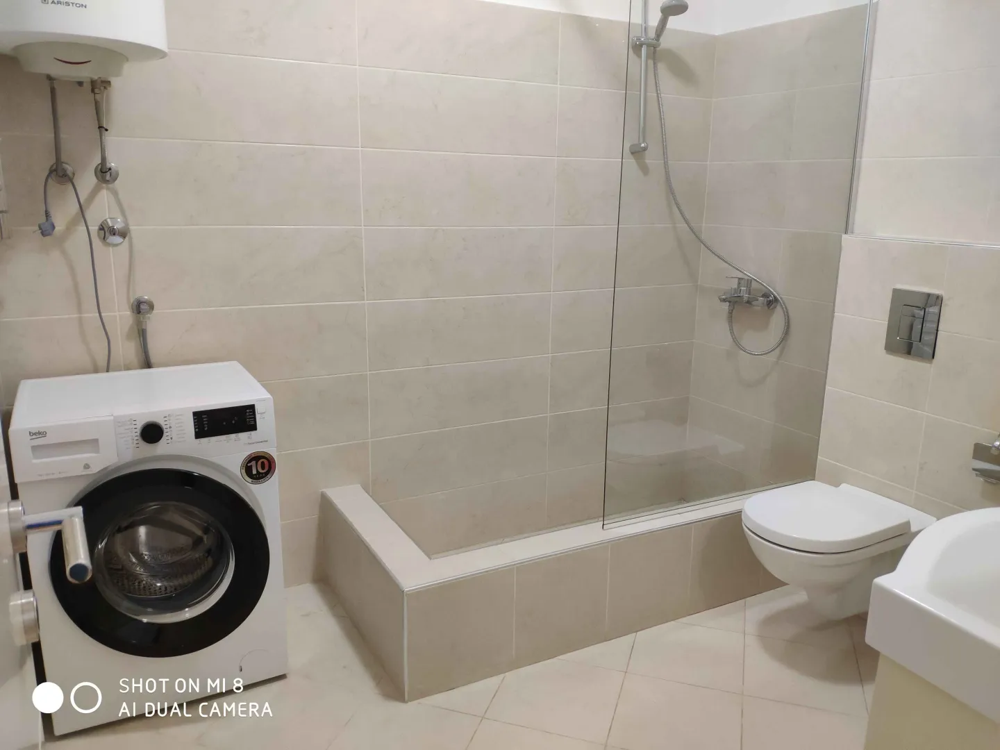 Bathroom with a shower and washing machine.