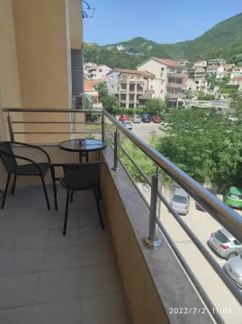 Small furnished balcony with a table and two chairs and a view of the neighborhood. - image 5