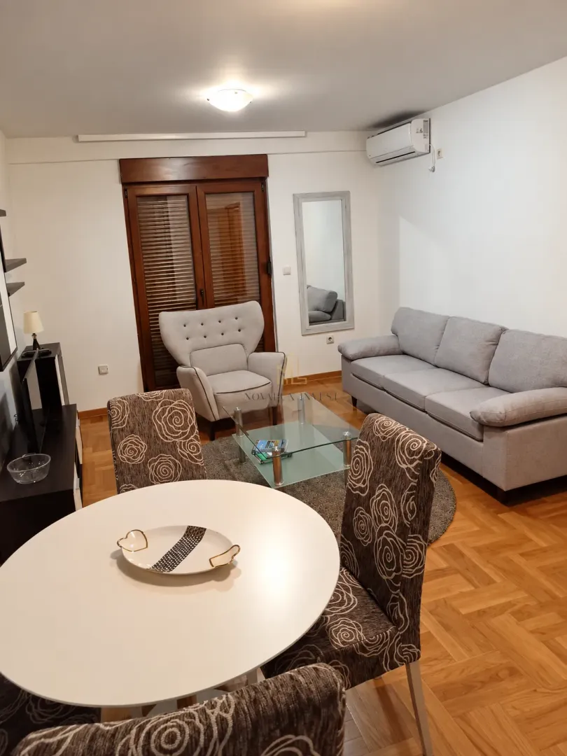 Living room with a sofa, armchair and a dining table.