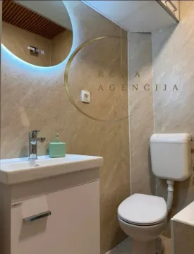 Modernly equipped bathroom with a vanity and toilet. - image 6