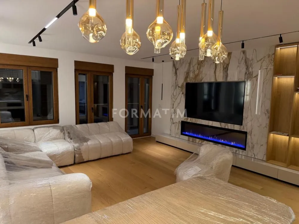 Modern living room with sofa, TV and fireplace.
