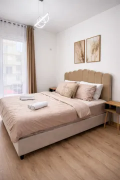 A furnished bedroom with a double bed, bedside tables, and a balcony door. - image 6
