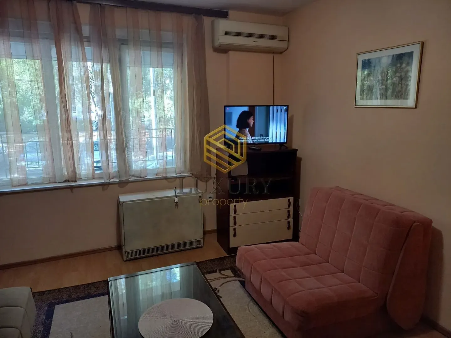 Living room with sofa, television, and window.