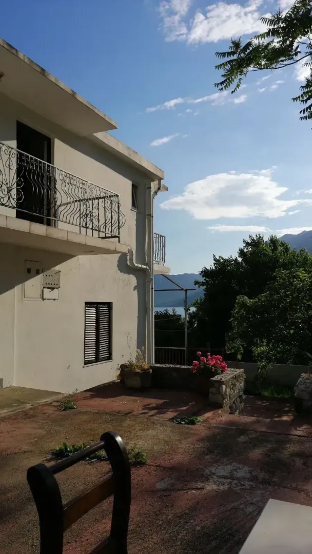View of the exterior of the house with a courtyard and balcony.