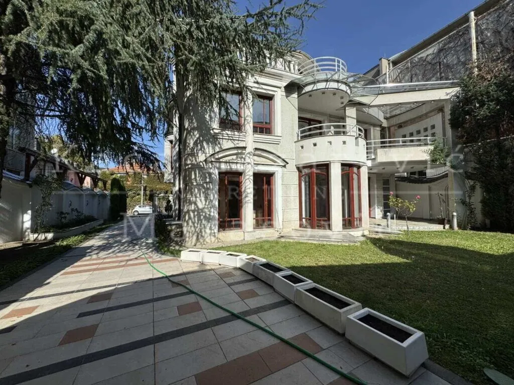 Exterior of a luxury house with a courtyard and paved pathways.