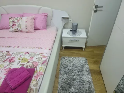 Bright bedroom with a double bed in pink tones and a nightstand. - image 27