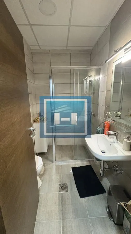 Modernly equipped bathroom with a shower cabin and a washbasin.