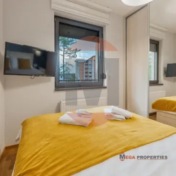 Nameštena spavaća soba sa bračnim krevetom, televizorom i plakarom. - image 10