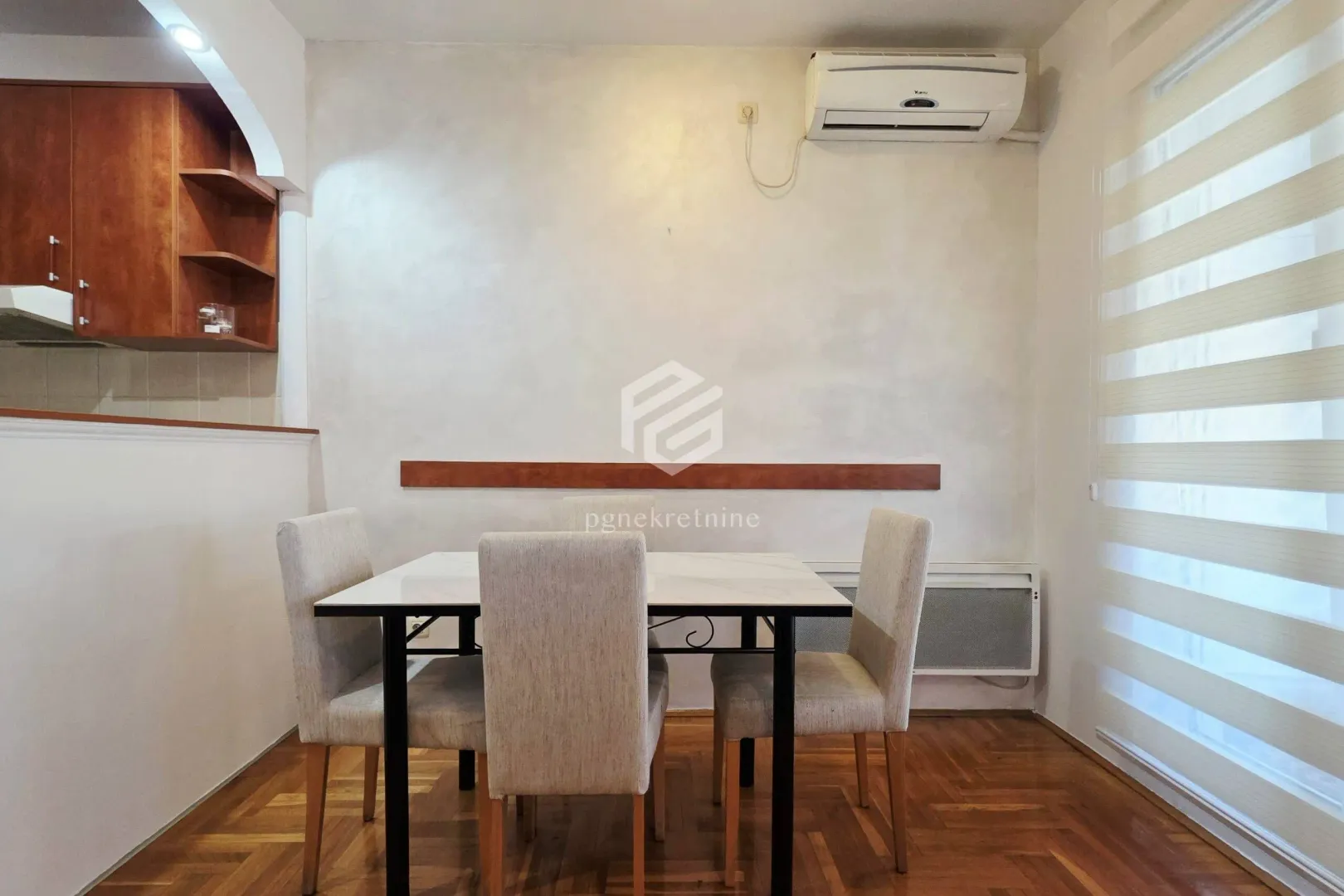 Dining area with a table, four chairs, and a wall-mounted air conditioner.
