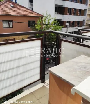 View from the balcony towards surrounding buildings and the street. - image 13