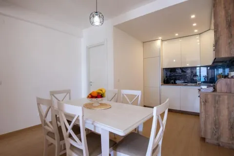 Trpezarija sa bijelim stolom i stolicama, povezana sa modernom kuhinjom. - image 6