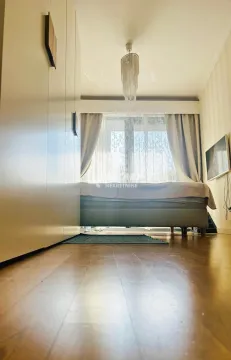 Spavaća soba sa bračnim krevetom, velikim ormarom i prozorom sa zavesama. - image 7