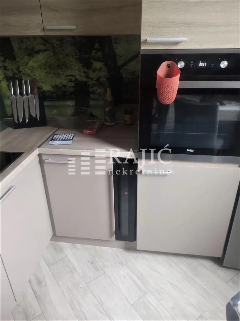 View of part of the kitchen with a built-in oven and cabinetry.