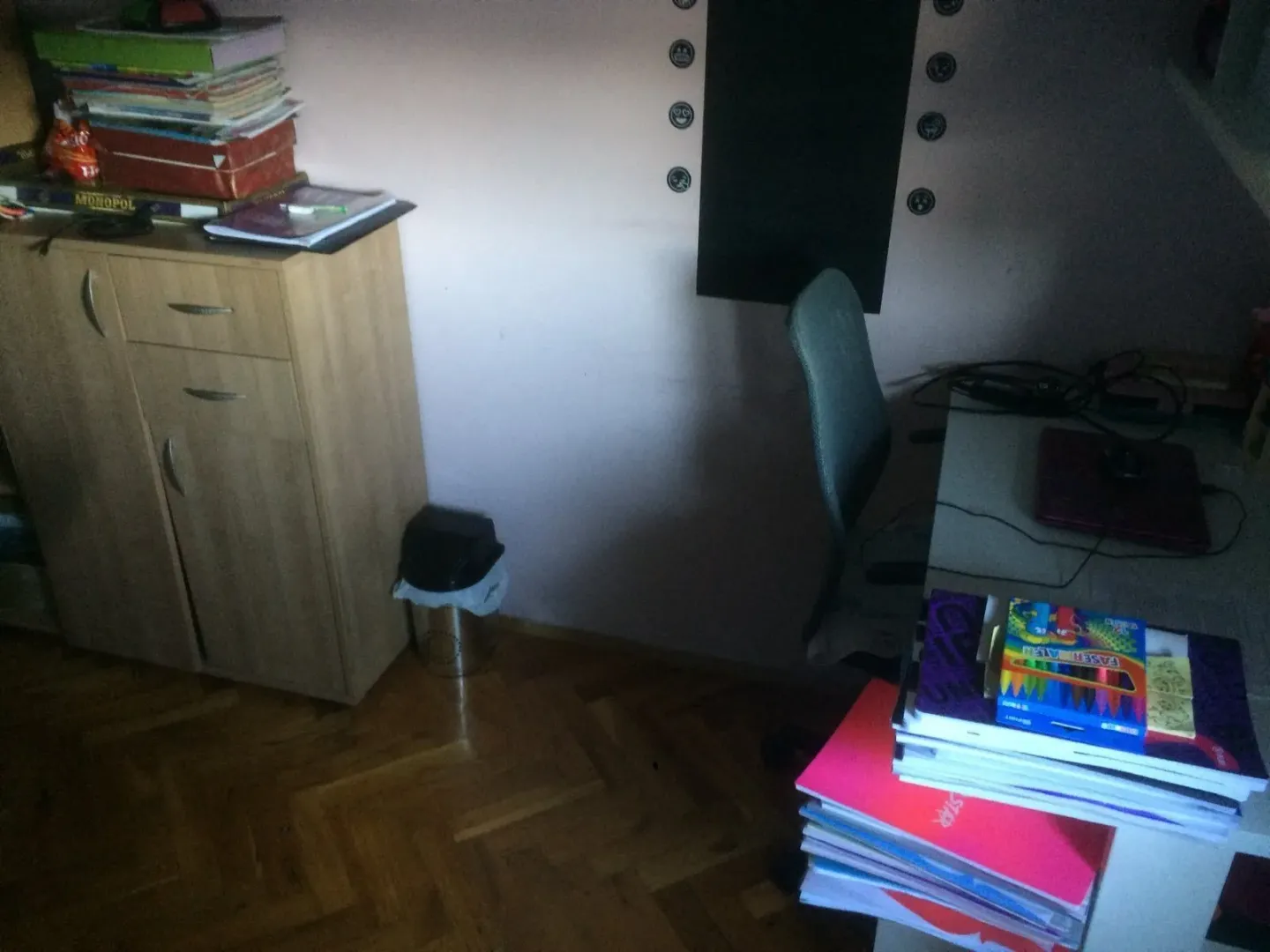 A study corner with a writing desk, chair, and a wooden cabinet.