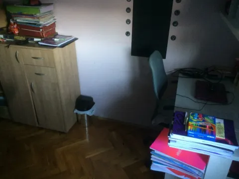 A study corner with a writing desk, chair, and a wooden cabinet. - image 16